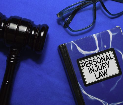 Personal Injury Law text on Book and gavel isolated on office desk.